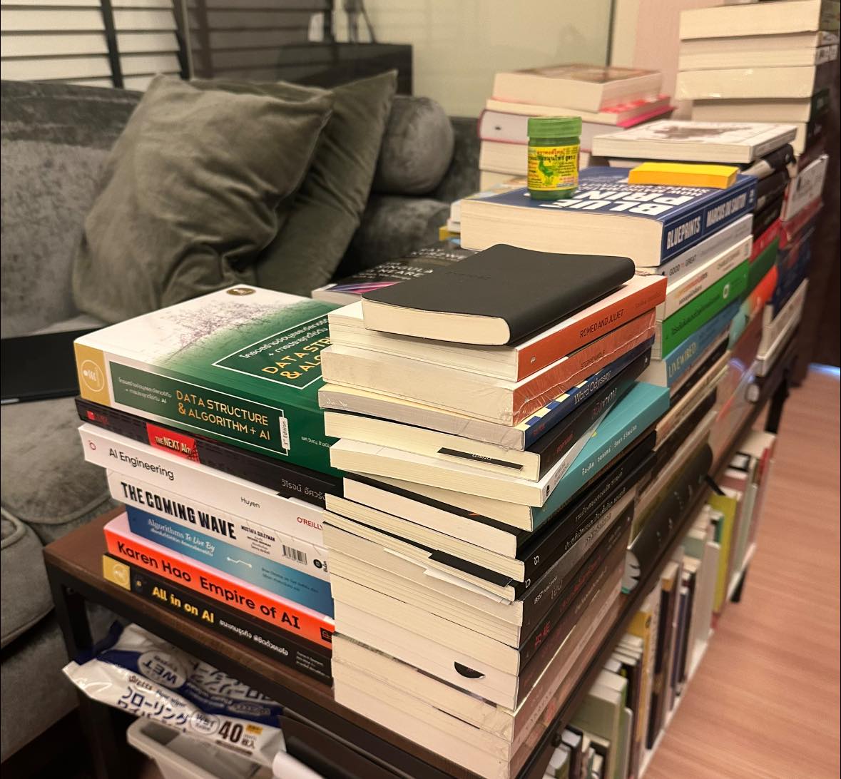 กองหนังสือหลายเล่มซ้อนกันอยู่บนโต๊ะ